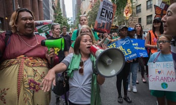 a crowd of activists marching with signs and megaphones