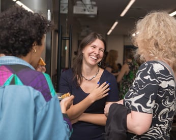 una mujer sonriendo mientras habla con otros